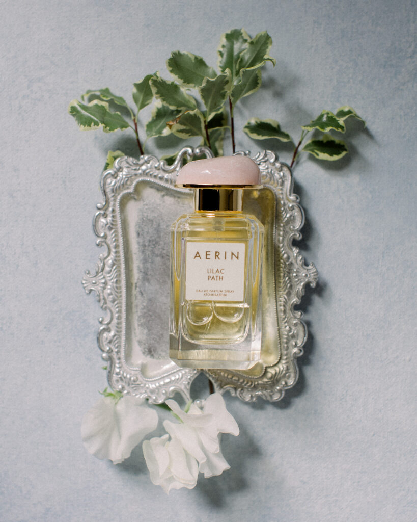 Aerin Lilc Path perfume bottle on top of a silver trinket dish and florals, wedding day details by Boston wedding photographer Ashley Helen