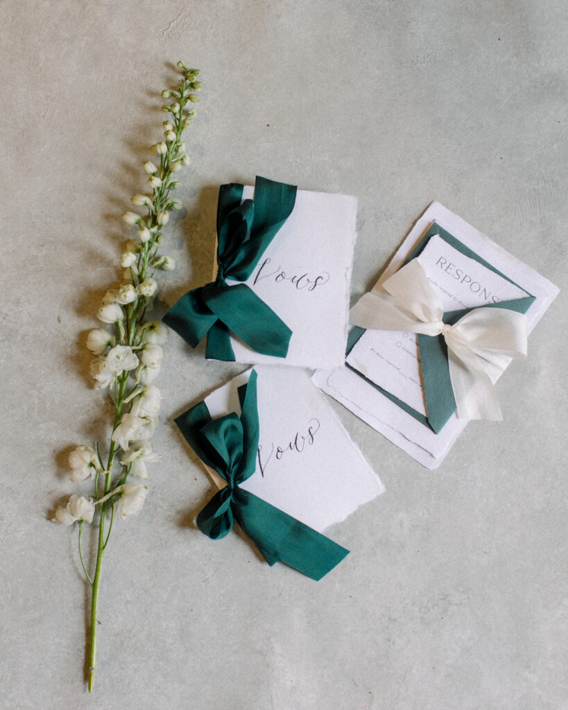 Deckled edge vow books with emerald green ribbon, wedding day details by Boston wedding photographer Ashley Helen